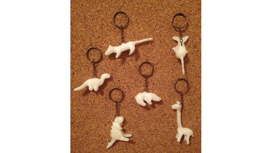 Glow in the dark keychains in the shape of dinosaurs made with InstaMorph moldable plastic.