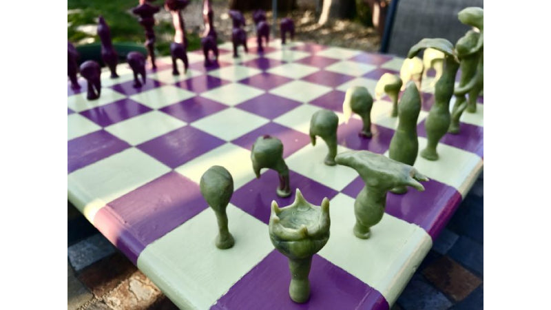 Chess set made out of InstaMorph moldable plastic. Chess board is white and purple squares. Chess pieces are grey or dark purple in color.